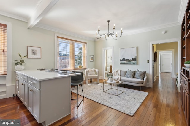 kitchen with a breakfast bar, a peninsula, dark wood-type flooring, crown molding, and open floor plan