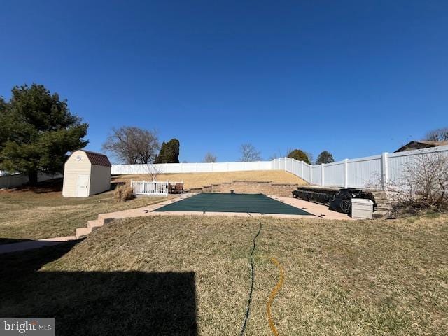 view of yard with a patio, a fenced in pool, a shed, a fenced backyard, and an outdoor structure