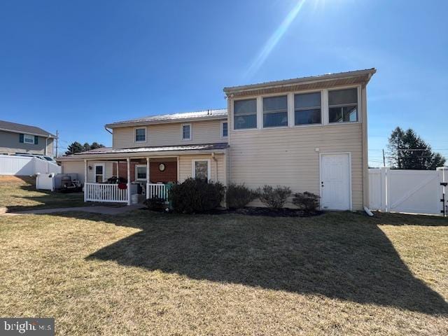 view of front of property with a front lawn, fence, and covered porch