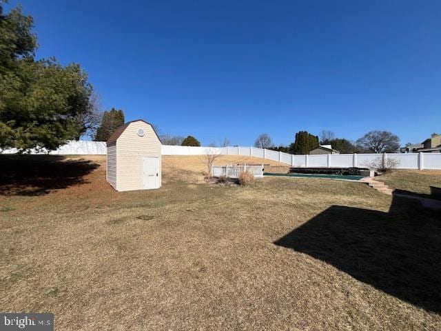 view of yard with a storage unit, an outbuilding, and a fenced backyard