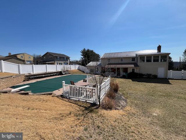 view of swimming pool featuring a fenced in pool, a yard, a fenced backyard, a diving board, and a patio area