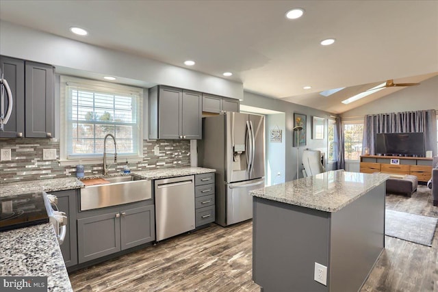 kitchen with a wealth of natural light, gray cabinetry, stainless steel appliances, and a sink