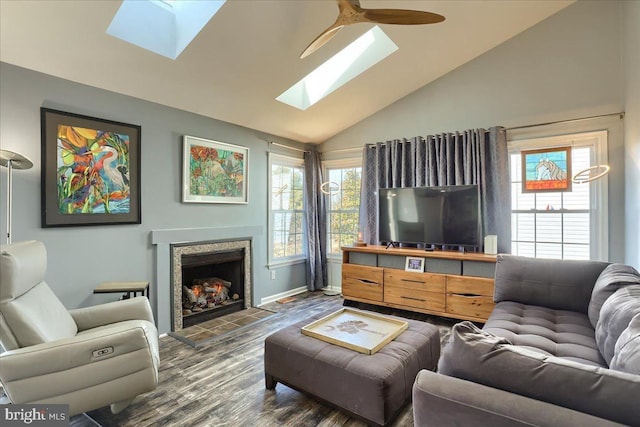 living room featuring dark wood finished floors, a healthy amount of sunlight, a fireplace, and lofted ceiling with skylight