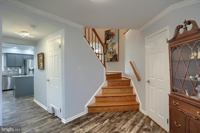 stairway featuring crown molding, baseboards, and wood finished floors
