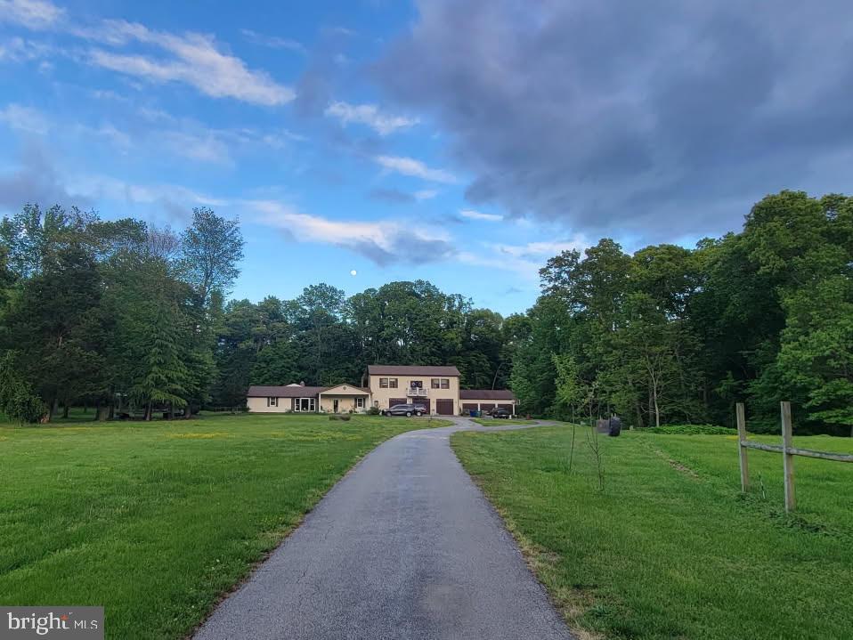 view of front facade featuring a forest view and a front yard