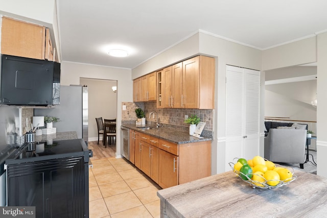 kitchen featuring tasteful backsplash, ornamental molding, light tile patterned floors, black appliances, and a sink