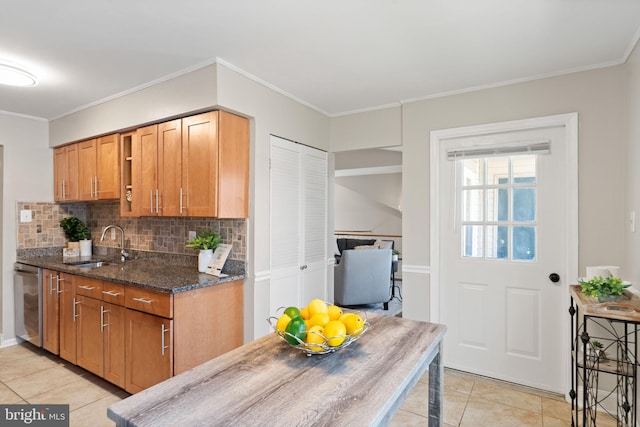 kitchen with backsplash, dark stone countertops, crown molding, and a sink