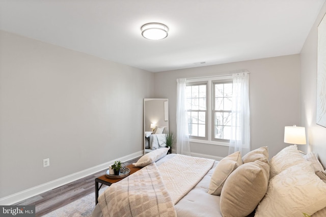 bedroom featuring baseboards and wood finished floors