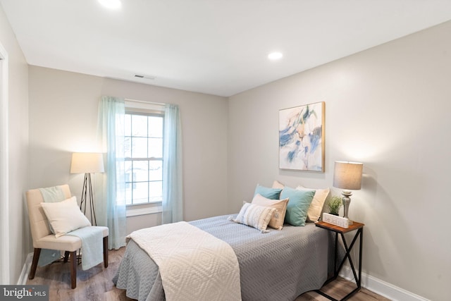 bedroom with recessed lighting, visible vents, baseboards, and wood finished floors