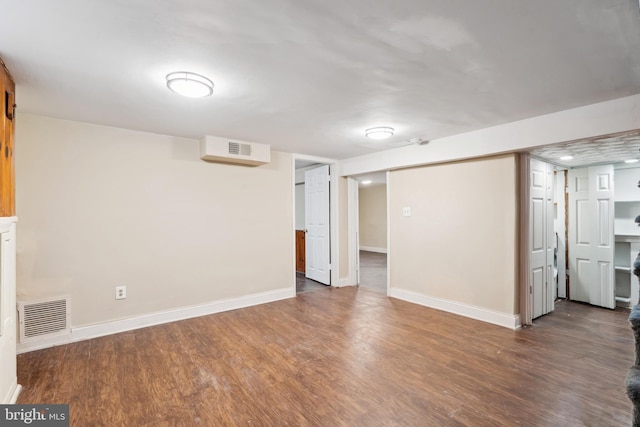 finished below grade area featuring visible vents, baseboards, and wood finished floors