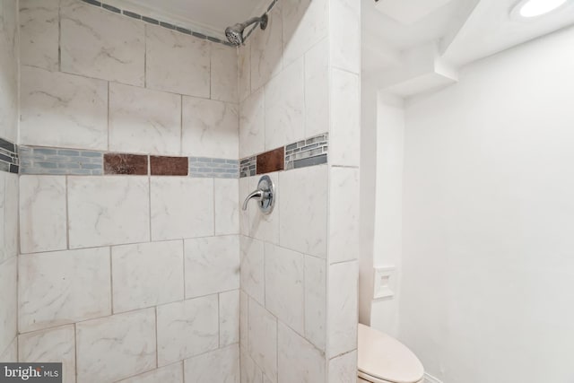 bathroom with toilet and a tile shower