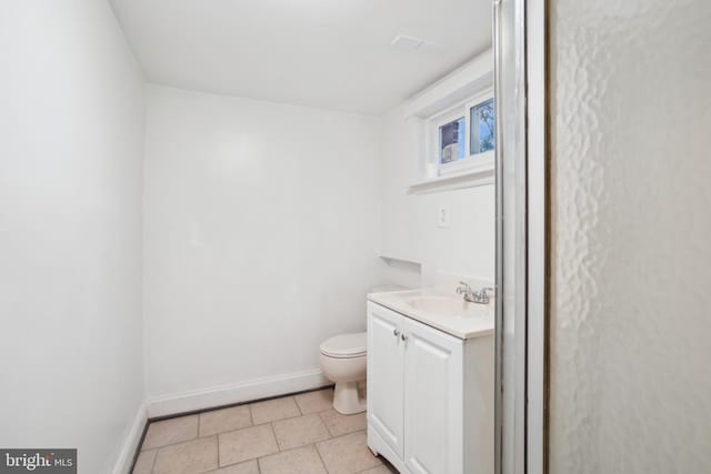 half bathroom featuring vanity, tile patterned floors, toilet, and baseboards