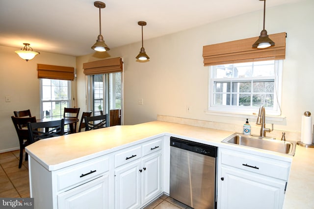 kitchen featuring a sink, a peninsula, white cabinetry, and stainless steel dishwasher