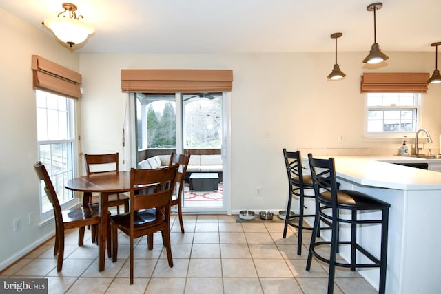 dining space featuring light tile patterned floors, baseboards, and a wealth of natural light