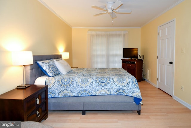 bedroom with light wood finished floors, a ceiling fan, baseboards, and ornamental molding