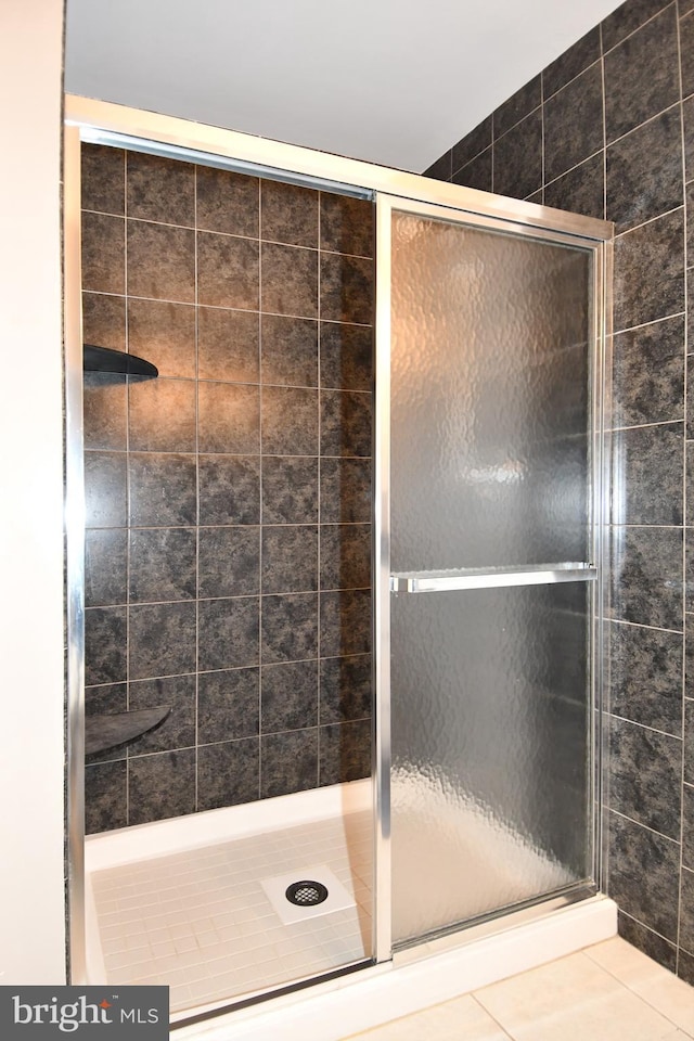 full bath with tile patterned flooring and a shower stall