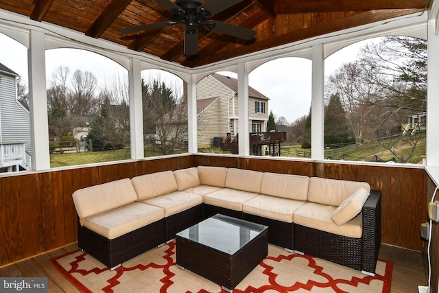 sunroom with lofted ceiling with beams, wood ceiling, a wealth of natural light, and ceiling fan