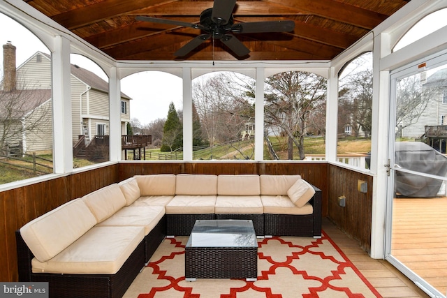 sunroom / solarium with wood ceiling, a ceiling fan, a healthy amount of sunlight, and vaulted ceiling with beams