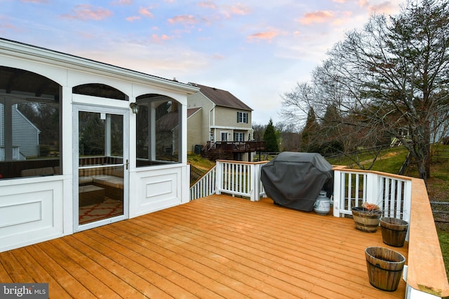 wooden terrace featuring a sunroom and grilling area