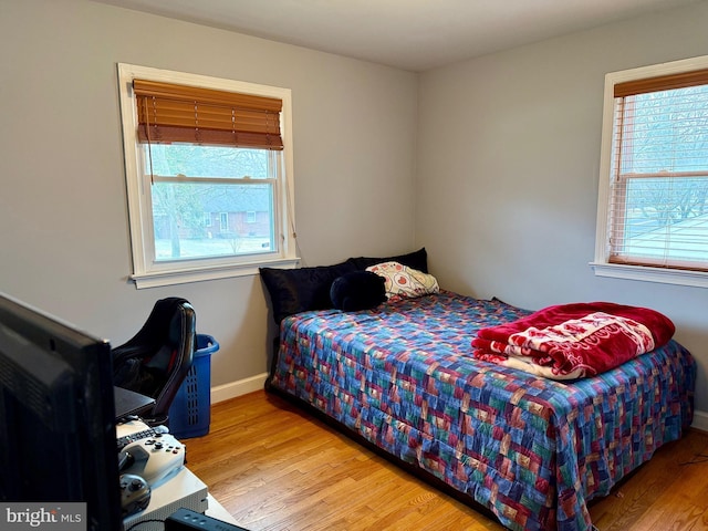 bedroom featuring baseboards and wood finished floors