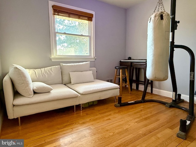 living area featuring baseboards and light wood finished floors