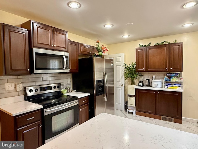 kitchen featuring light tile patterned floors, visible vents, stainless steel appliances, and light countertops