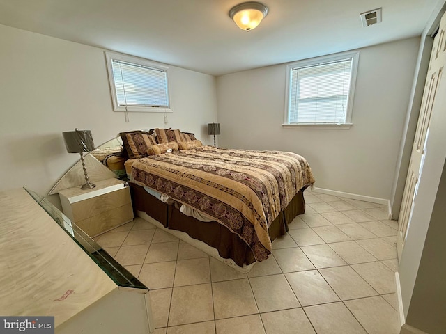 bedroom featuring light tile patterned flooring, visible vents, and baseboards