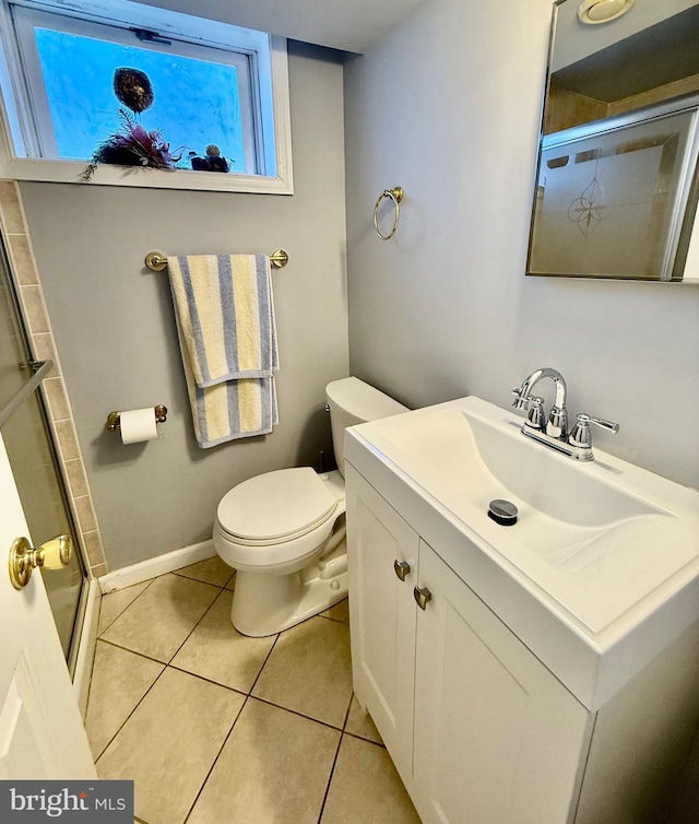 bathroom featuring vanity, baseboards, an enclosed shower, tile patterned floors, and toilet