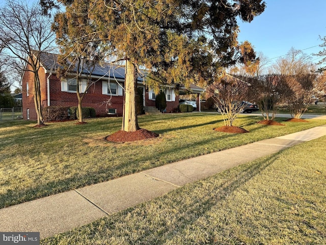 view of front of home featuring a front yard and brick siding