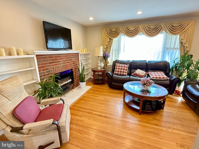 living room with recessed lighting, wood finished floors, and a fireplace