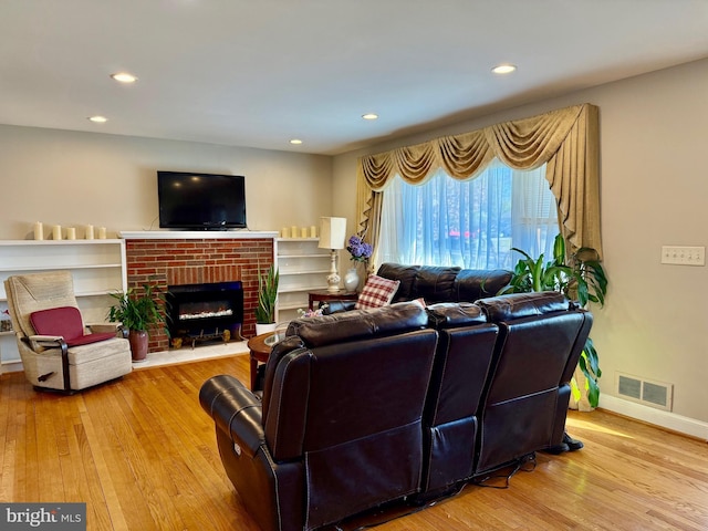 living area featuring visible vents, recessed lighting, wood-type flooring, a fireplace, and baseboards