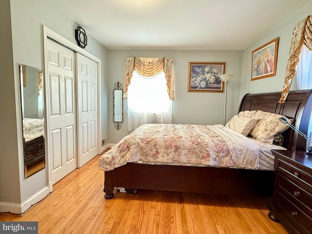 bedroom featuring a closet, baseboards, and light wood-style floors