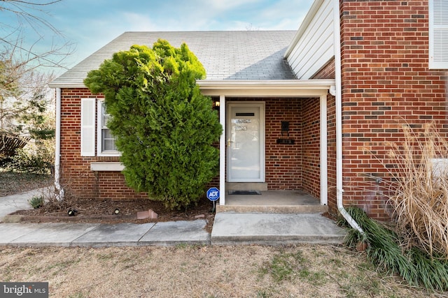 doorway to property with brick siding