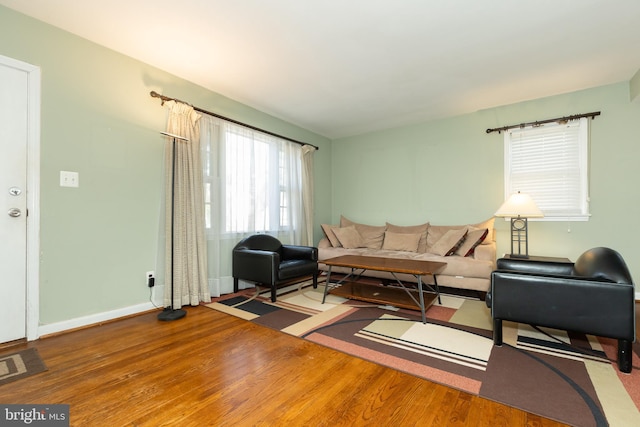 living room featuring visible vents, baseboards, and wood finished floors