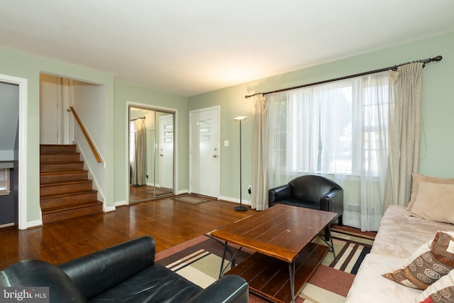 living area with stairs, baseboards, and wood finished floors