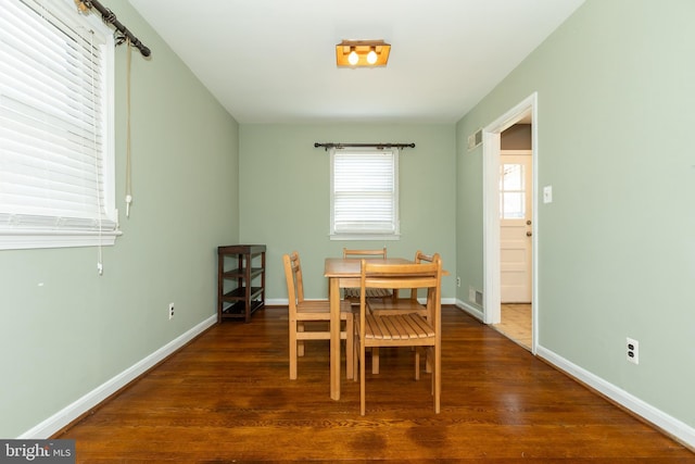 dining area featuring visible vents, baseboards, and wood finished floors