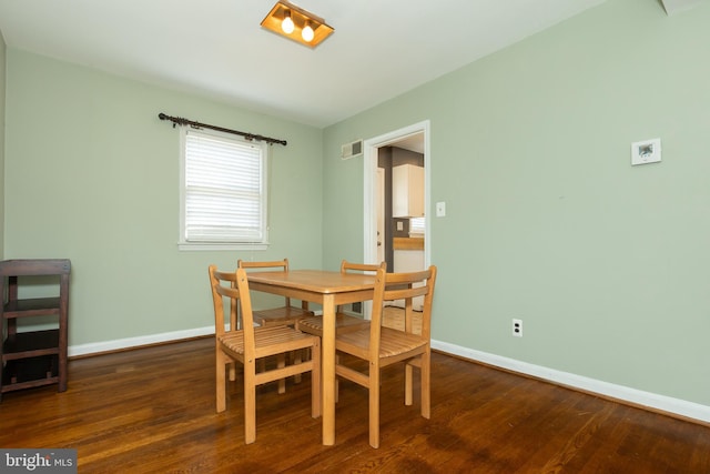 dining space with wood finished floors, baseboards, and visible vents