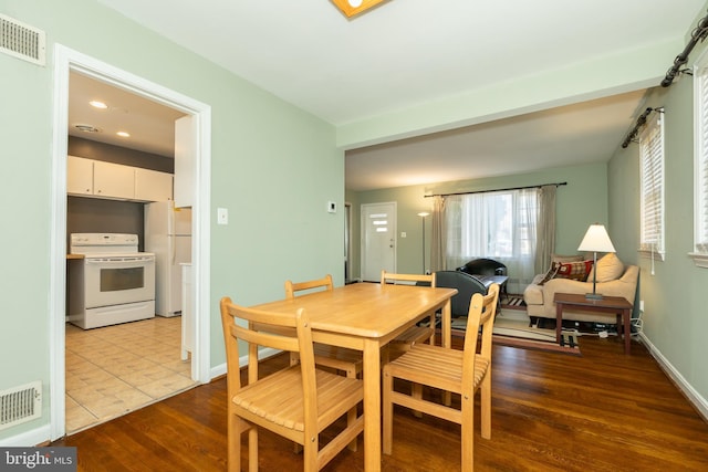 dining room with visible vents, dark wood-type flooring, and baseboards