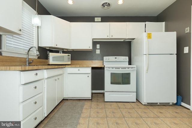 kitchen with white appliances, visible vents, recessed lighting, a sink, and white cabinetry