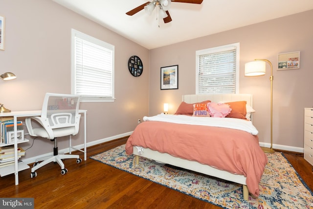 bedroom featuring multiple windows, baseboards, and wood finished floors