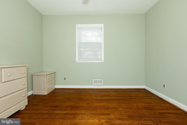 unfurnished bedroom featuring dark wood-type flooring, baseboards, and visible vents