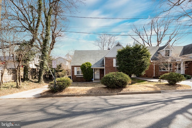 new england style home featuring brick siding