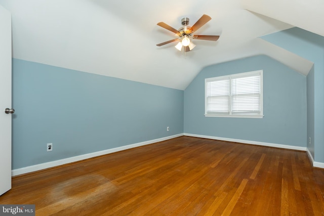 additional living space with vaulted ceiling, wood finished floors, baseboards, and ceiling fan