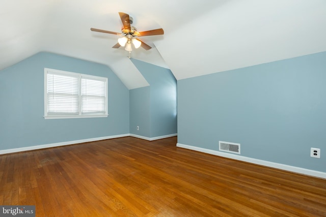 additional living space featuring visible vents, baseboards, vaulted ceiling, and hardwood / wood-style flooring