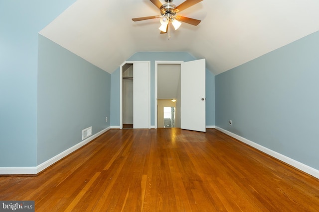 additional living space featuring visible vents, lofted ceiling, wood-type flooring, baseboards, and ceiling fan