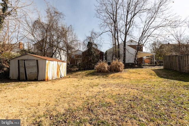 view of yard featuring a shed, an outdoor structure, and fence