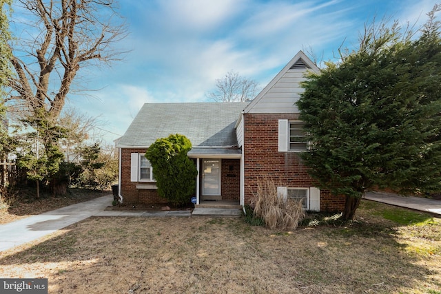 view of front of house featuring brick siding, central air condition unit, and a front lawn