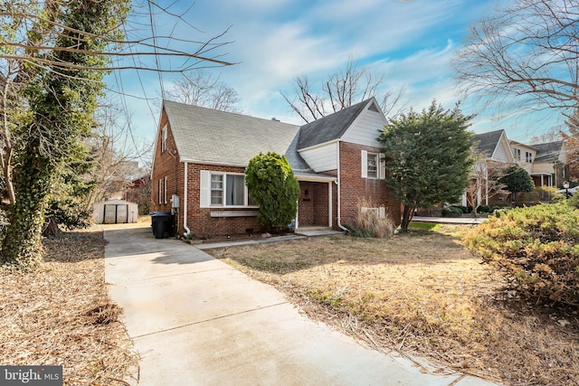 view of front of home with an outbuilding and brick siding