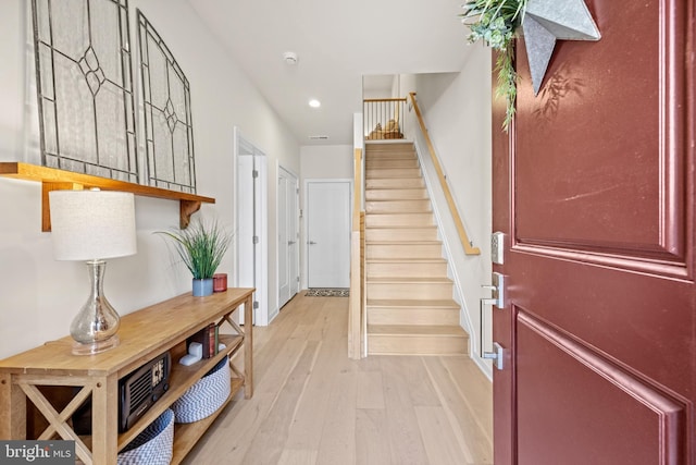 foyer entrance featuring stairs, recessed lighting, light wood-type flooring, and baseboards