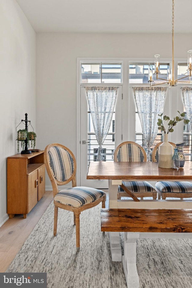 dining space featuring a chandelier and baseboards